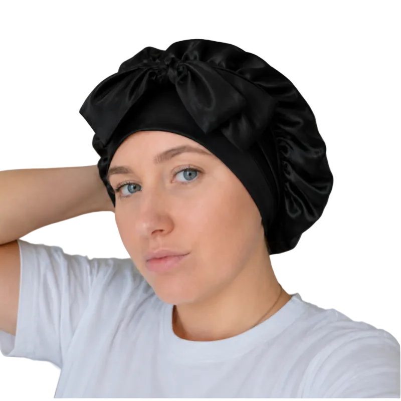 Woman wearing a purple mulberry silk bonnet for overnight hair protection.